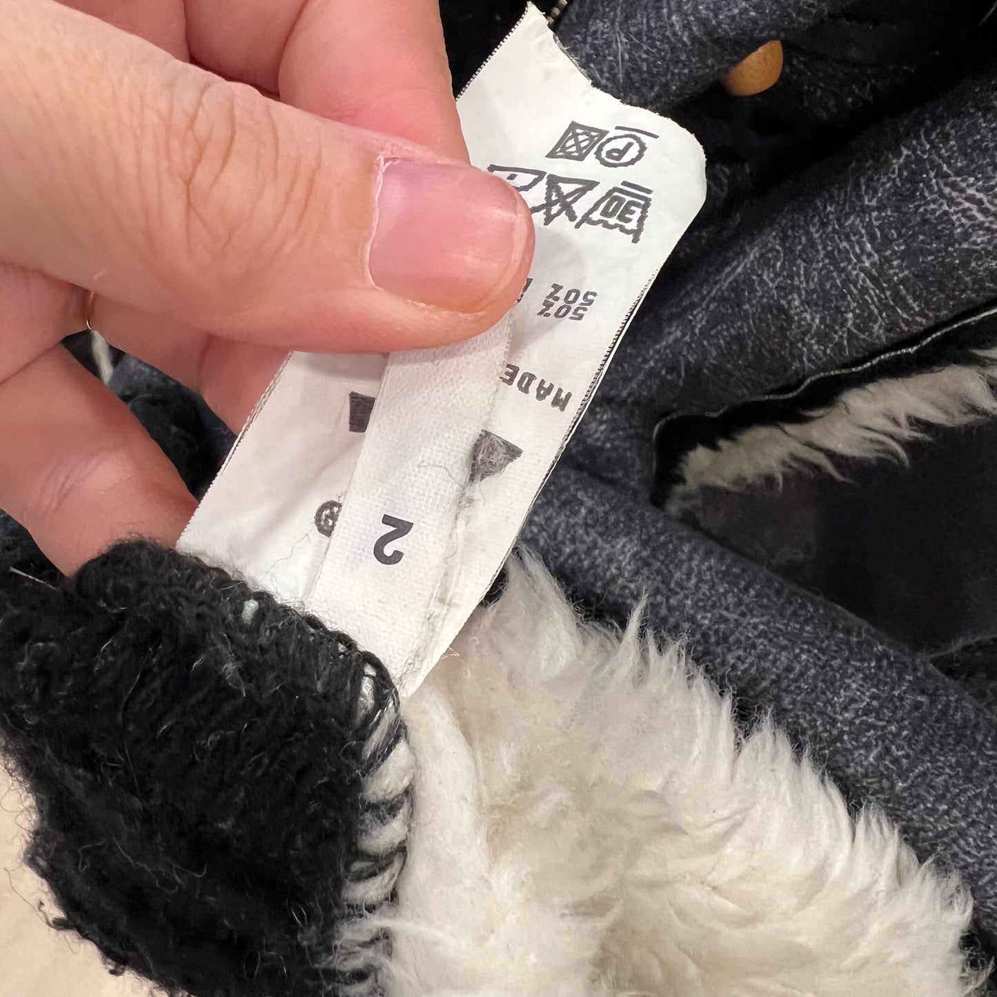 Close-up of a hand holding a label on a product with black and white details