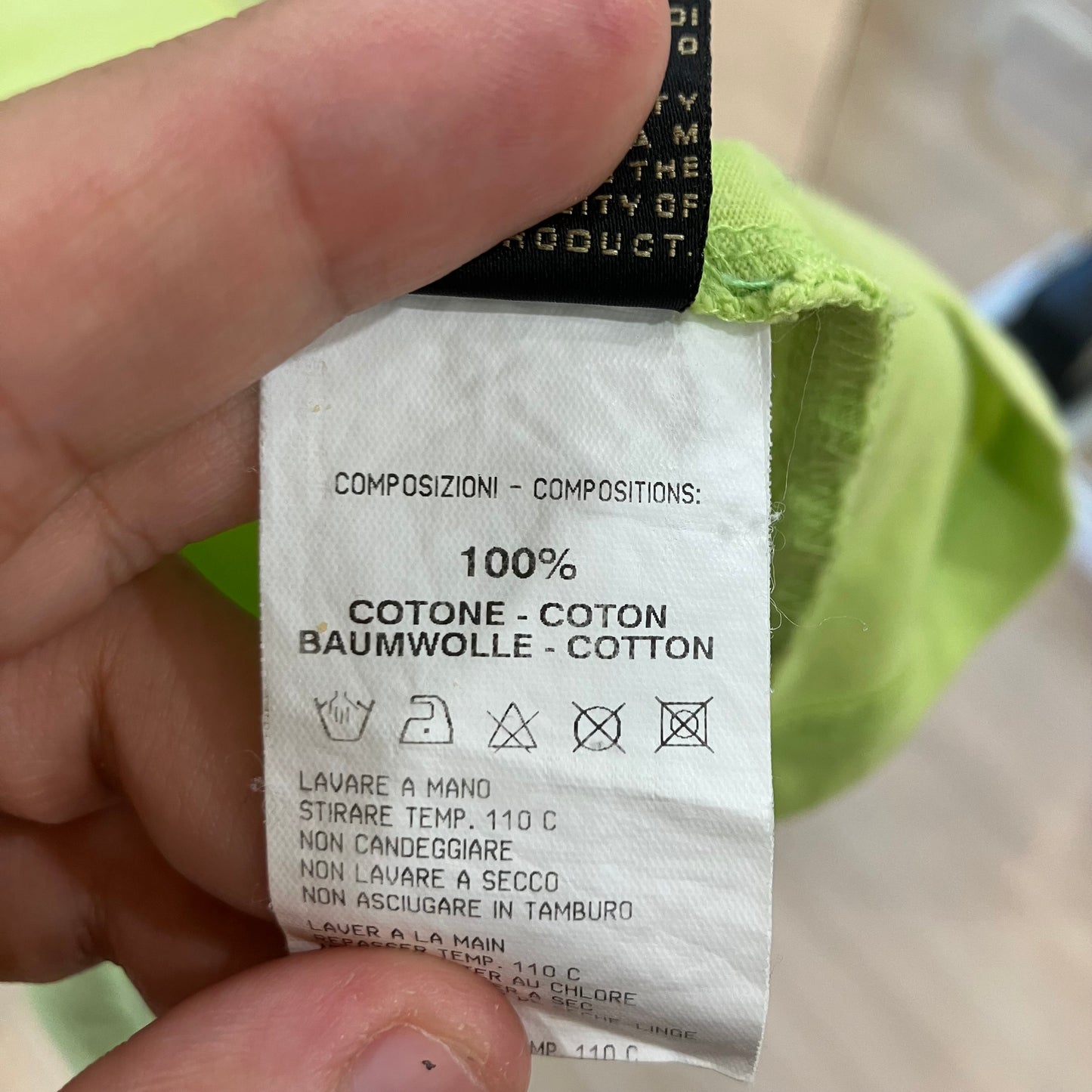 Clothing label with text and symbols on a green fabric background