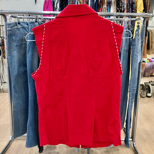 Red vest on a rack with jeans in a store setting