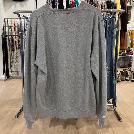 Gray sweatshirt hanging on a rack in a store setting
