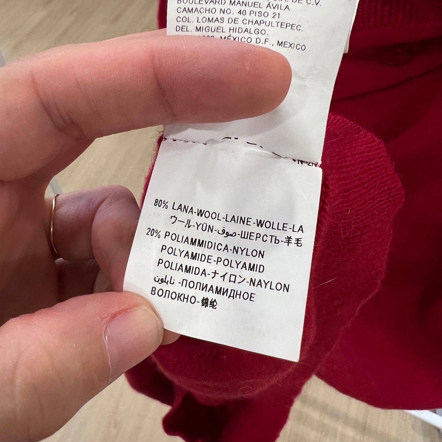 Close-up of a clothing label with text on a red garment.