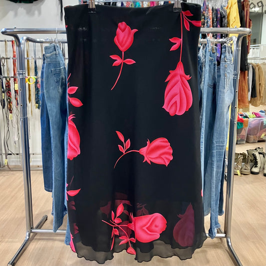 Black dress with pink floral patterns on a clothing rack in a store