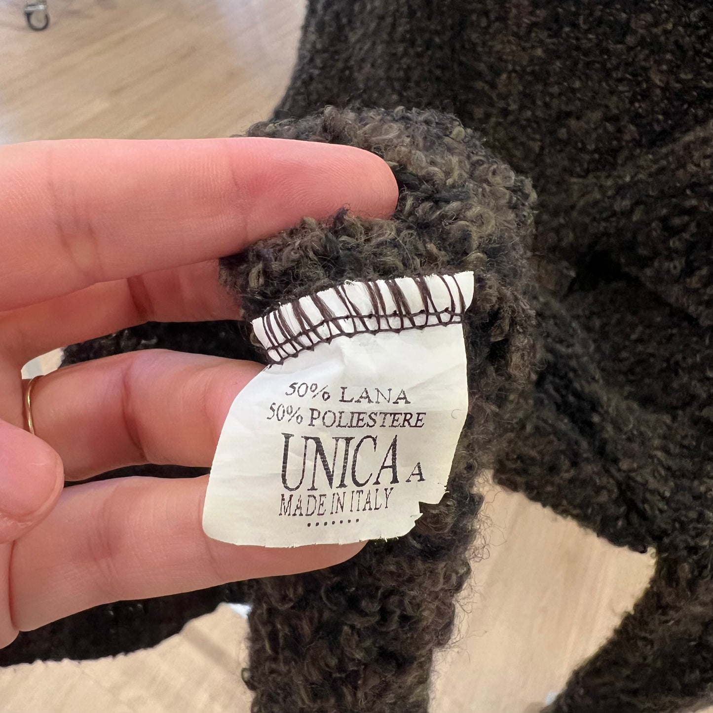 Close-up of a label on a textured fabric with 'UNICA' branding
