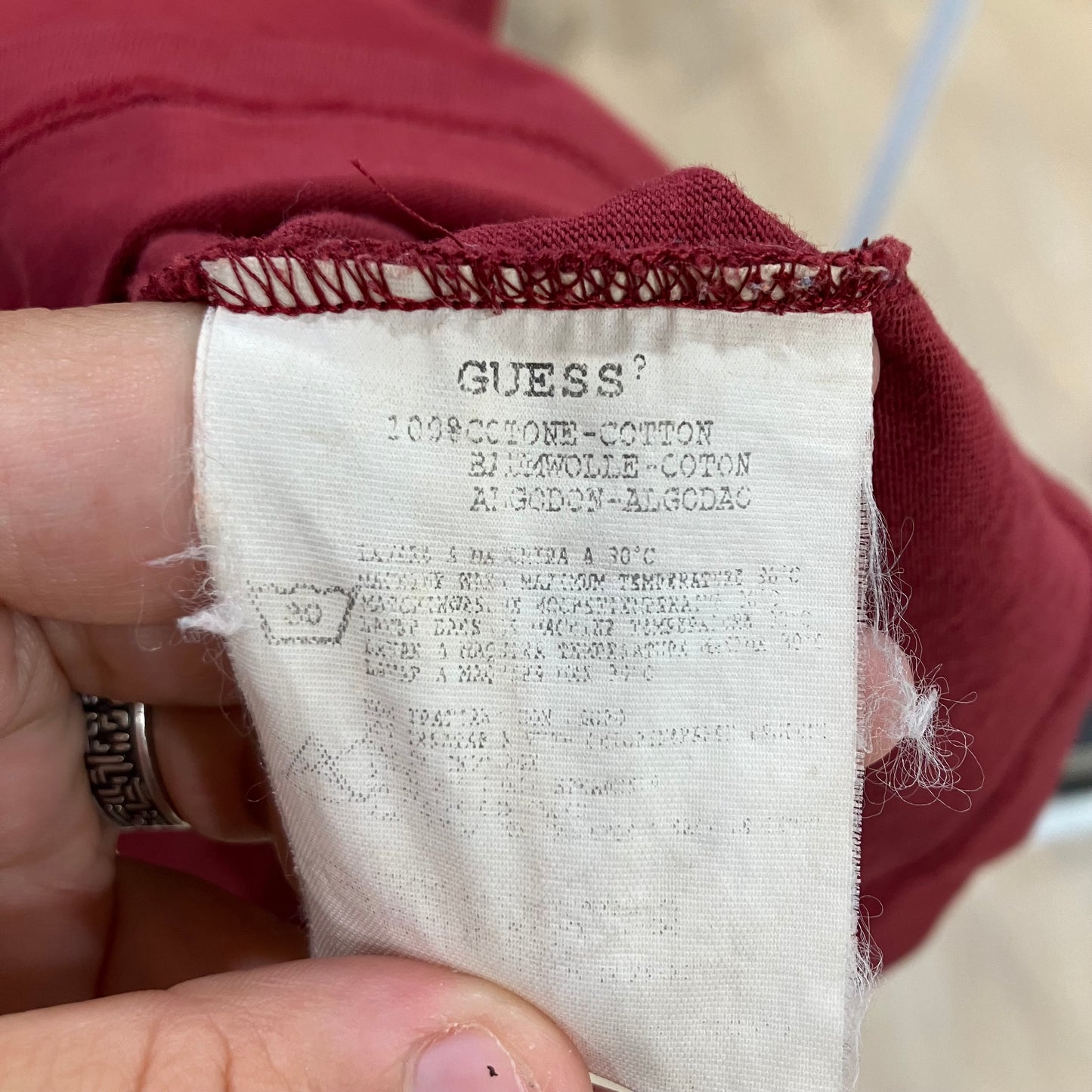 Close-up of a Guess fabric label on red material