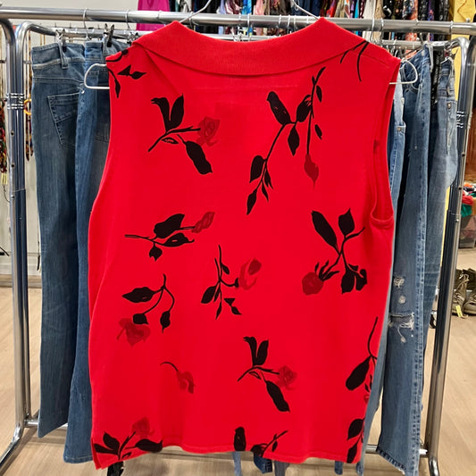 Red sleeveless top with black floral patterns on a clothing rack