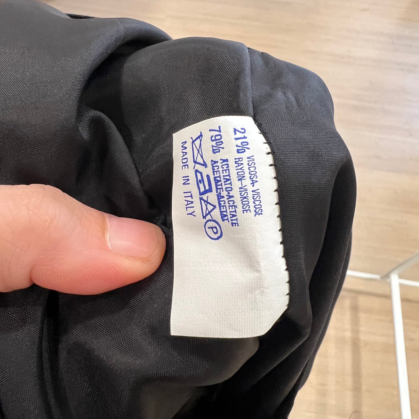 Clothing label on a dark fabric with 'Made in Italy' text