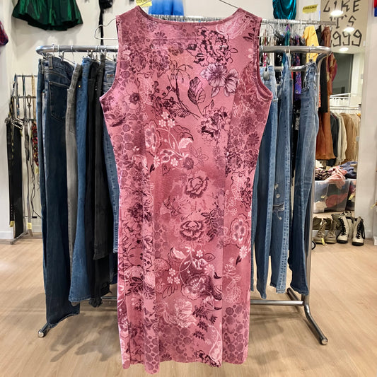 Pink floral dress on a rack with jeans in a store setting