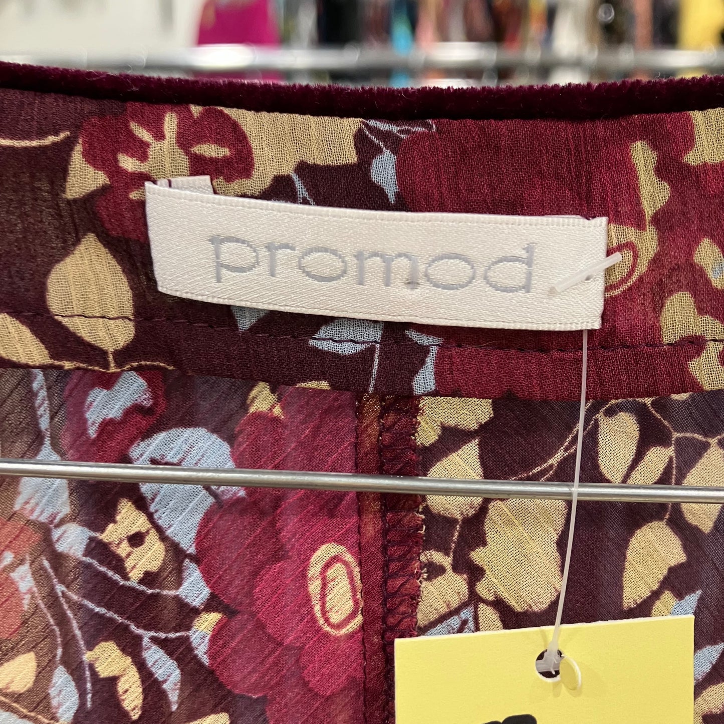 Floral-patterned fabric with 'promod' label and yellow tag