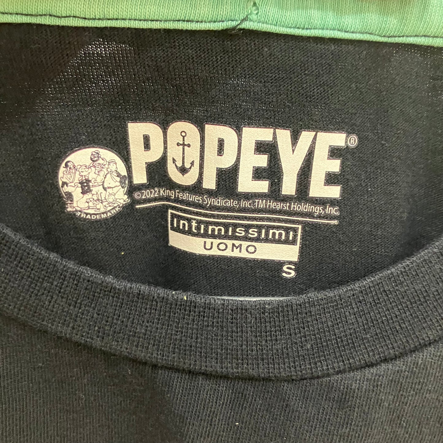 Close-up of a Popeye logo on a garment label with 'Intimissimi Uomo' branding