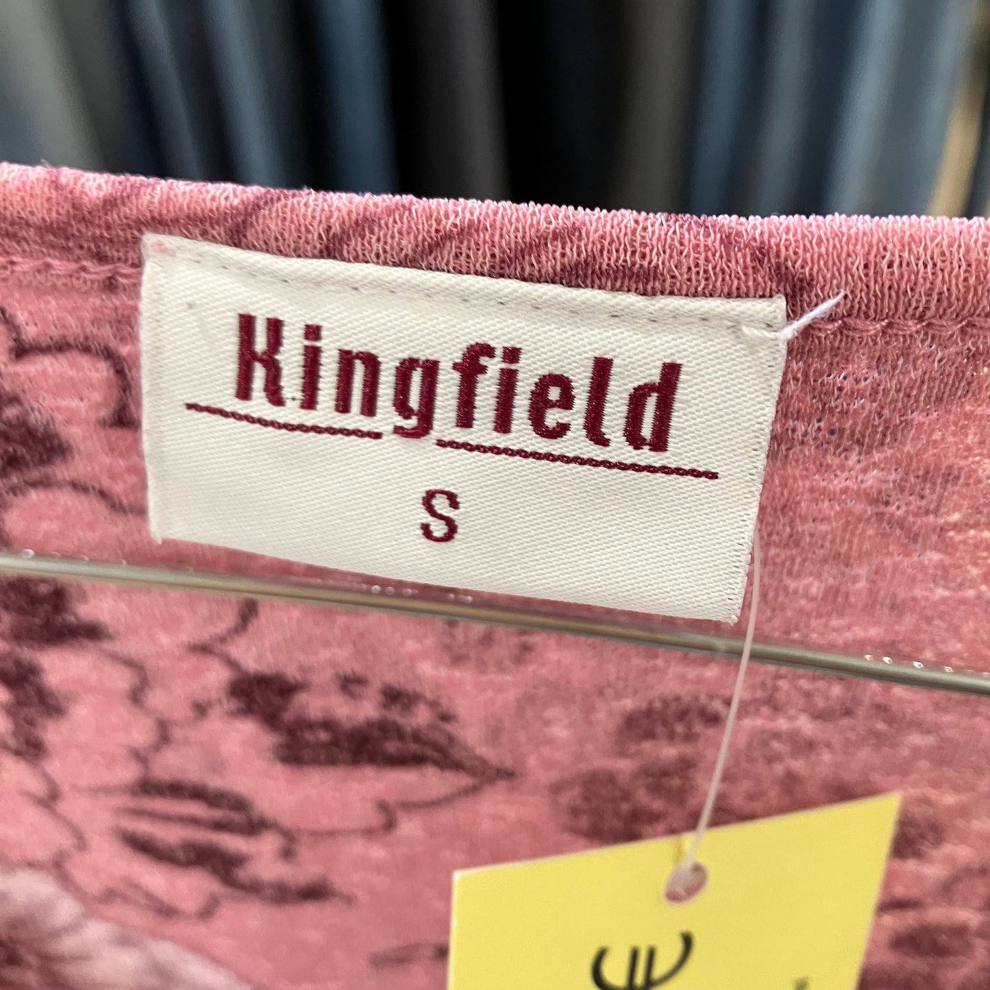 Kingfield label on a pink garment with a blurred background