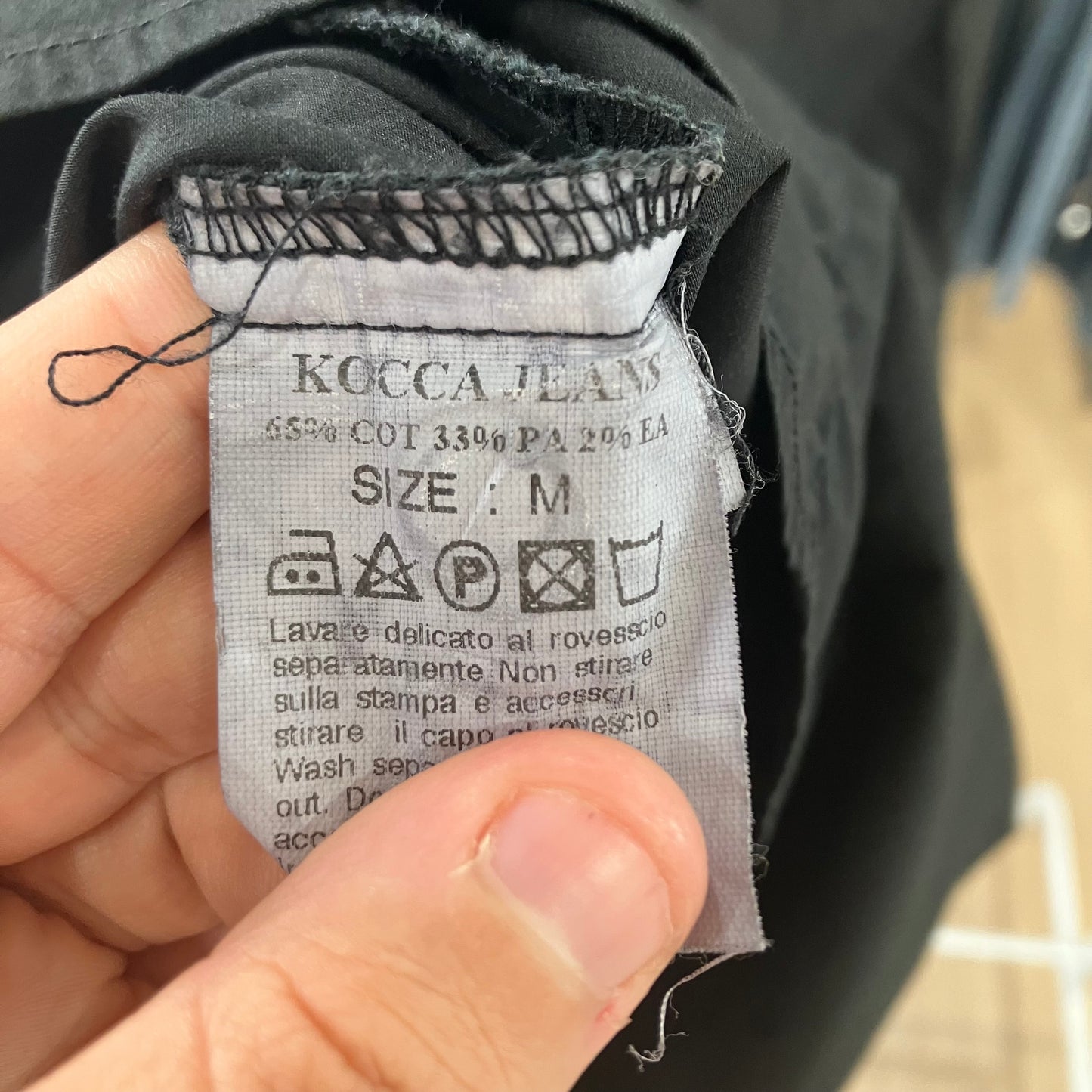 Close-up of a clothing label on a garment with visible text and symbols