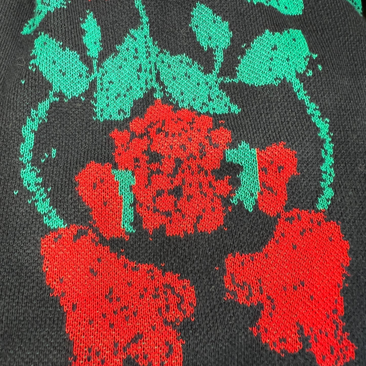 Close-up of a black fabric with red and green floral patterns