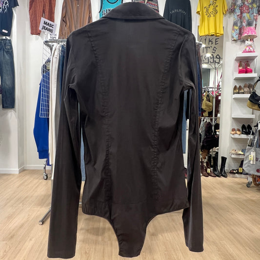 Black shirt in a store setting with various clothing items in the background