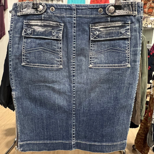 Blue denim skirt on a hanger with a blurred store background