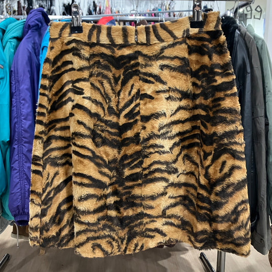 Tiger-striped patterned fabric on a rack with other clothing items in the background