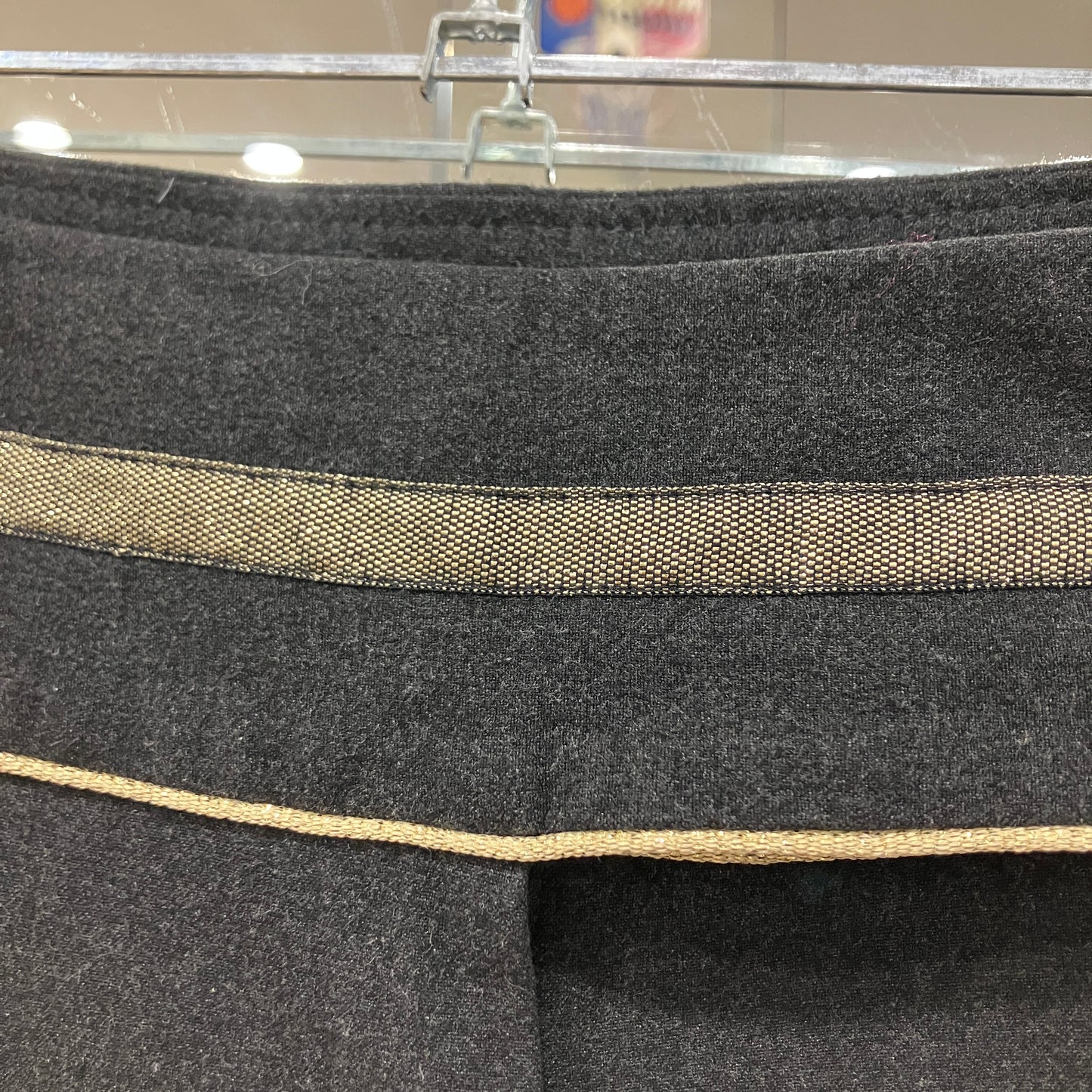 Close-up of a gray fabric with a gold trim on a hanger