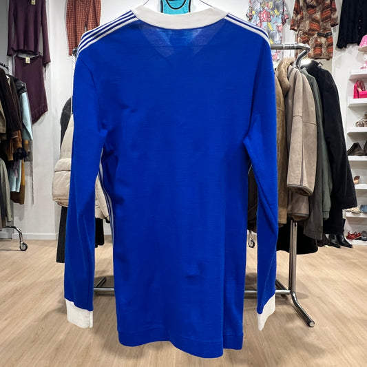 Blue long-sleeve dress with white trim on a hanger in a clothing store