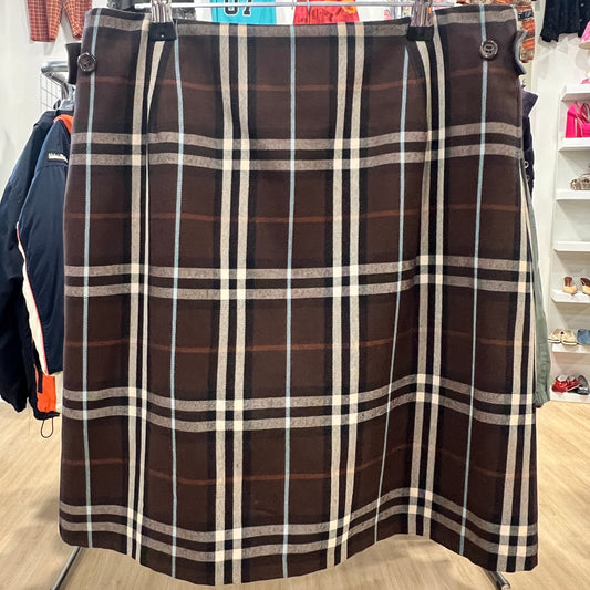 Plaid skirt hanging in a store with clothing in the background
