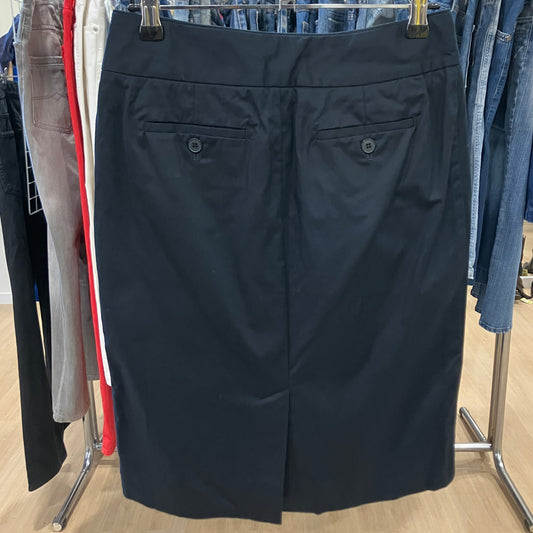 Black skirt hanging on a rack with other clothing items