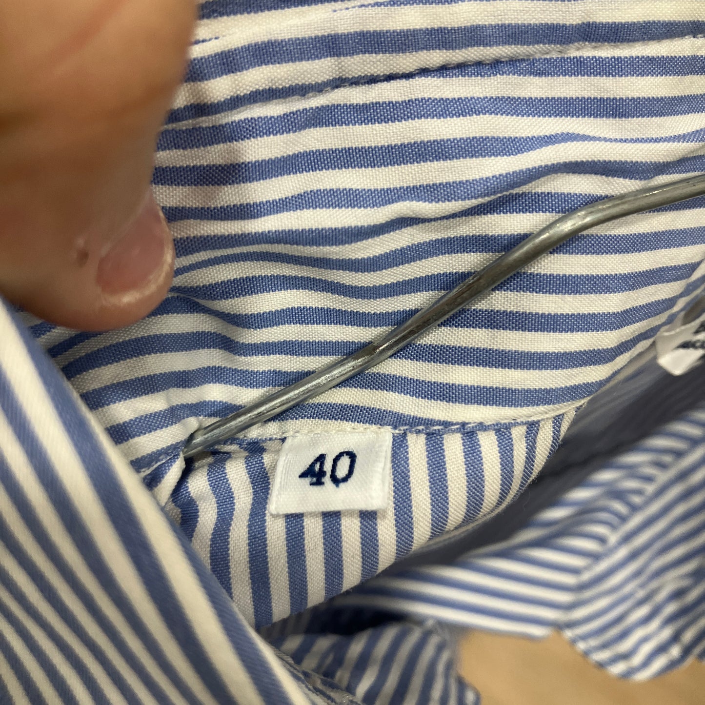 Close-up of a blue and white striped shirt with a size tag showing '40'