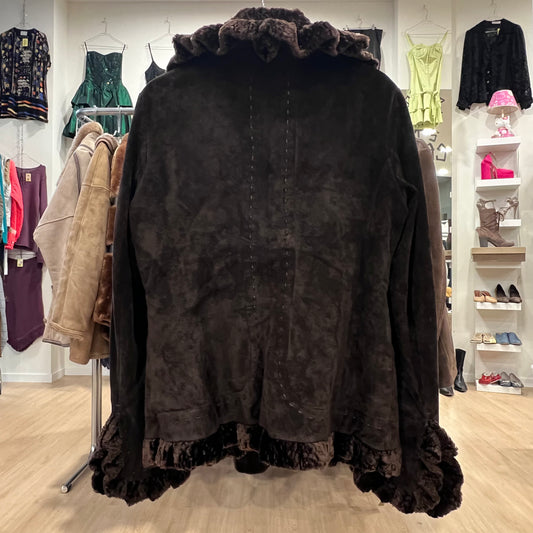 Dark brown coat with ruffled trim hanging in a store setting