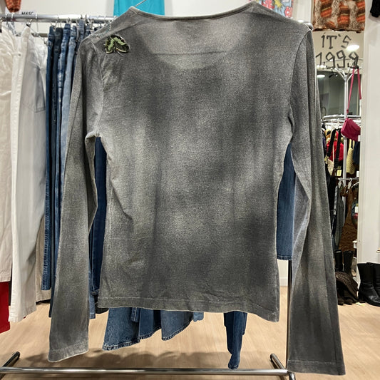 Gray long-sleeve top on a mannequin in a clothing store setting