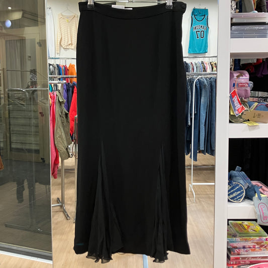 Black skirt hanging in a store with clothing racks and shelves in the background