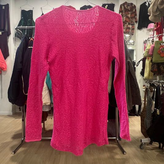 Pink textured long-sleeve top on a rack in a clothing store