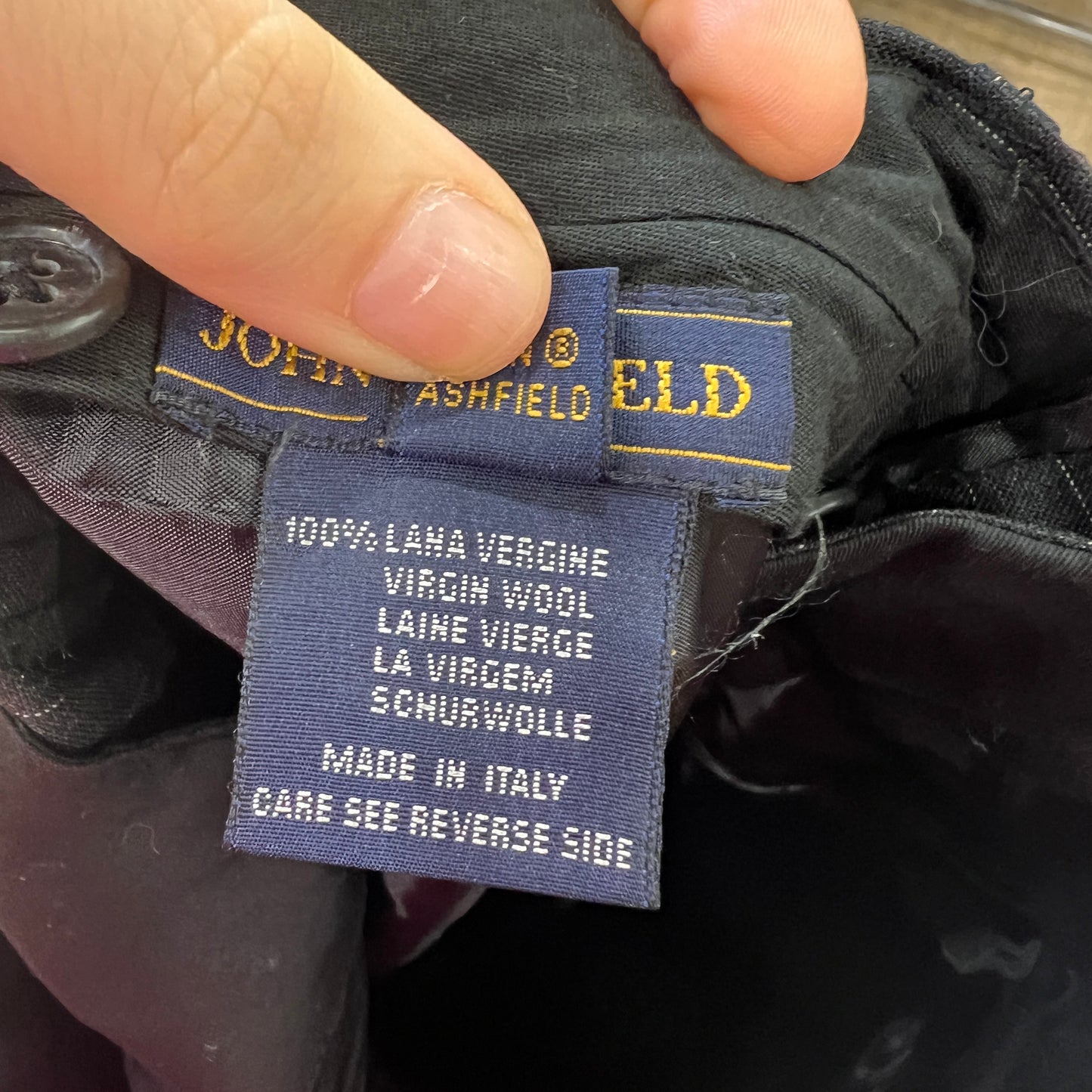 Clothing label on a garment with 'John Ashfield' branding and text details
