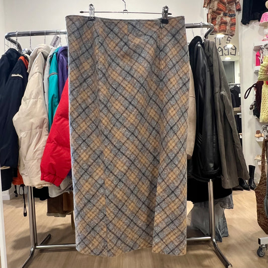 Plaid skirt hanging on a rack in a store with various clothing items in the background