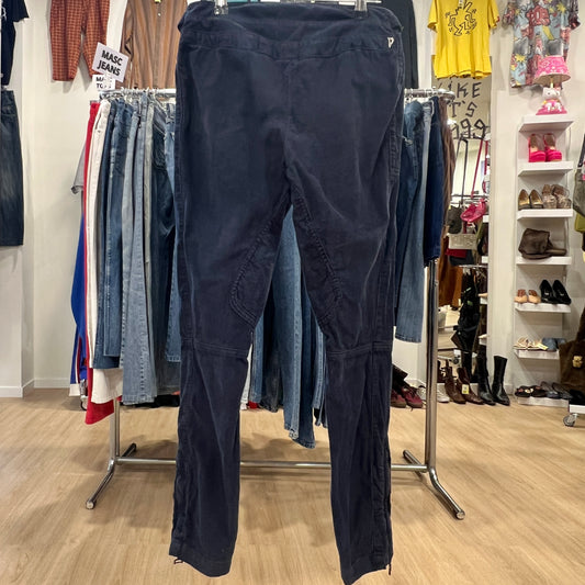 Navy blue pants hanging on a rack in a store with clothing and shoes in the background