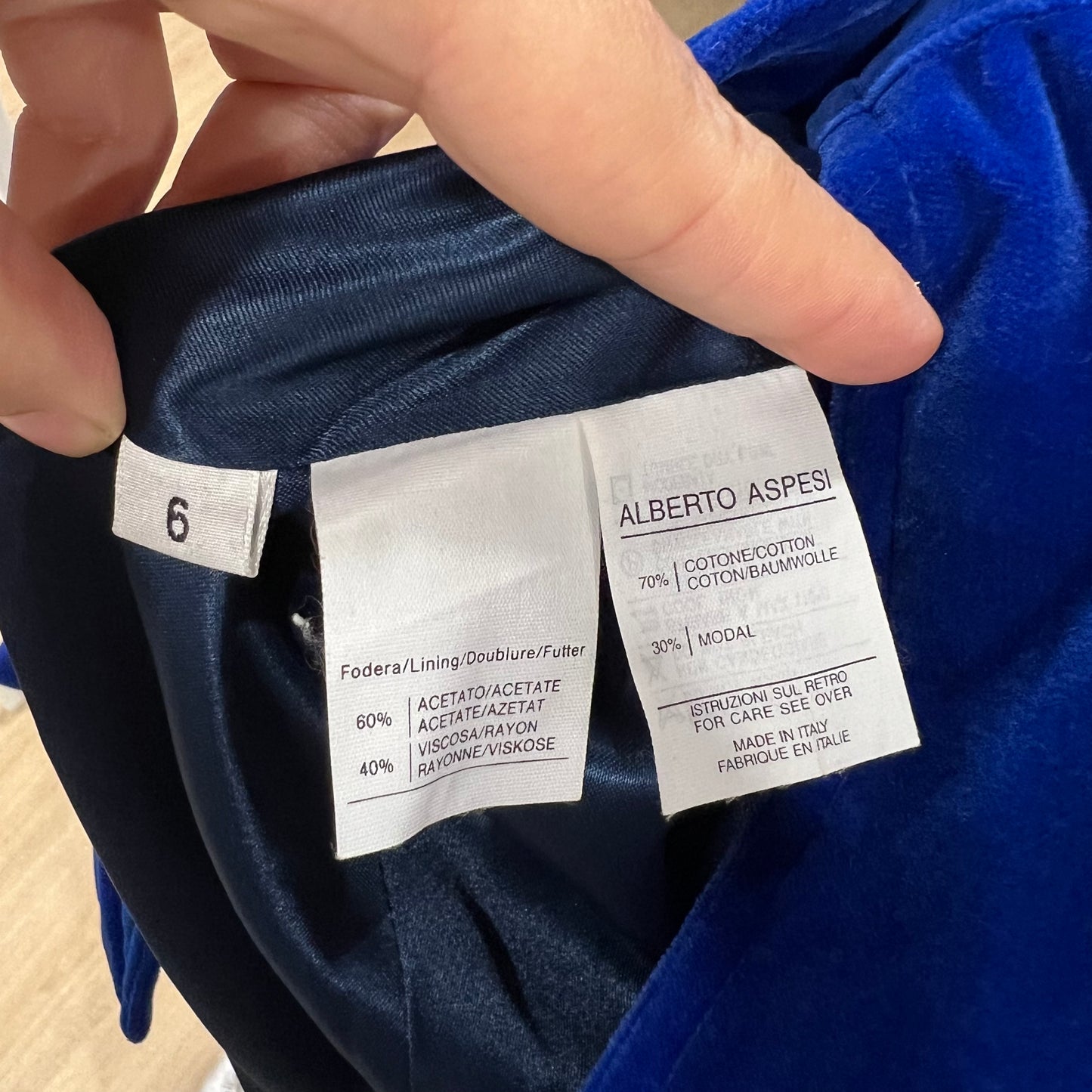 Clothing label with 'Alberto Aspesi' on a blue garment