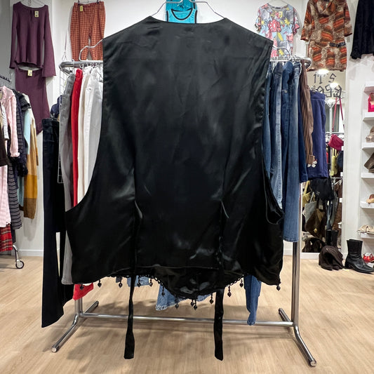 Black satin jacket on a clothing rack with a store interior background