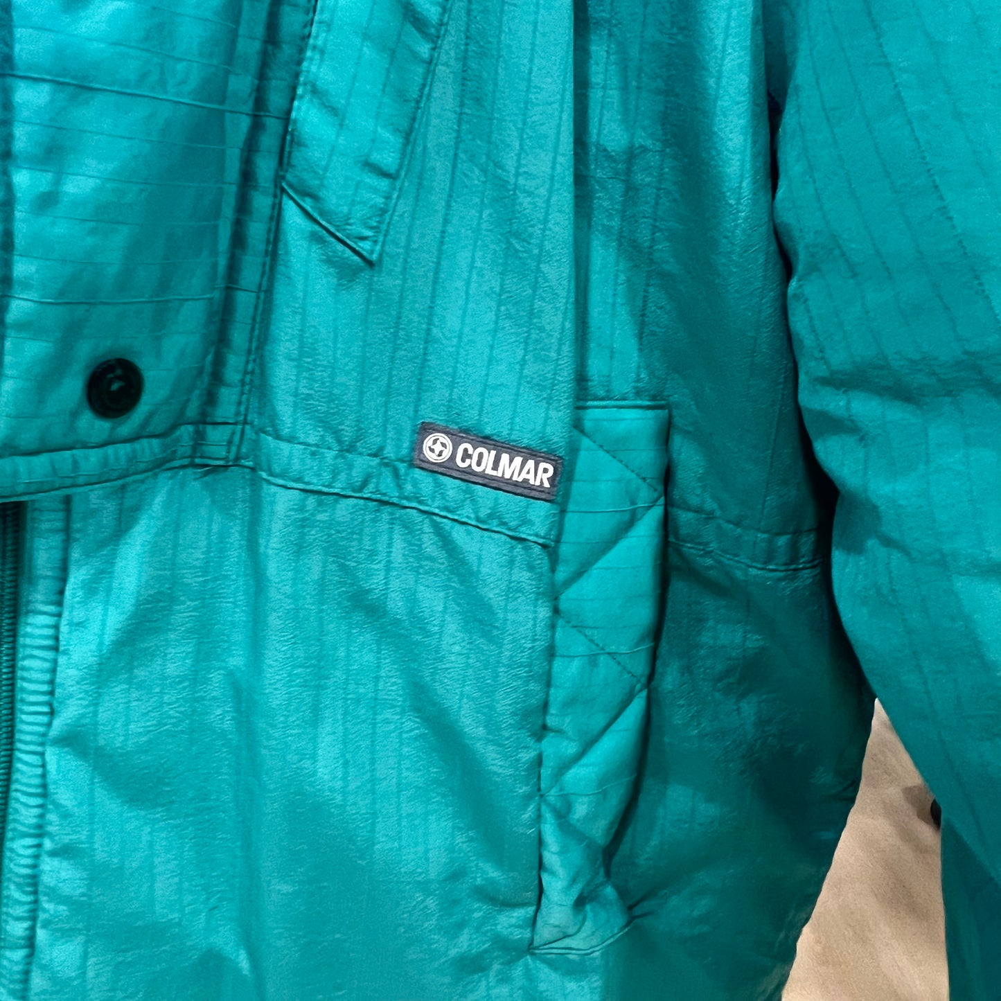 Teal jacket with Colmar logo on a pocket