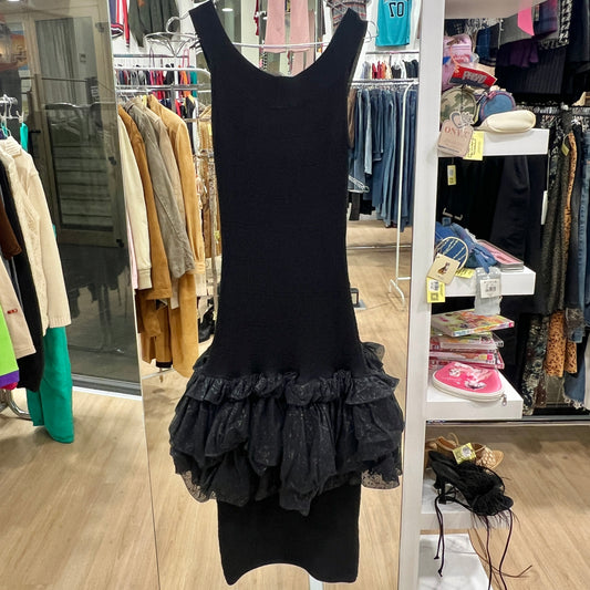 Black dress with ruffled bottom hanging in a store