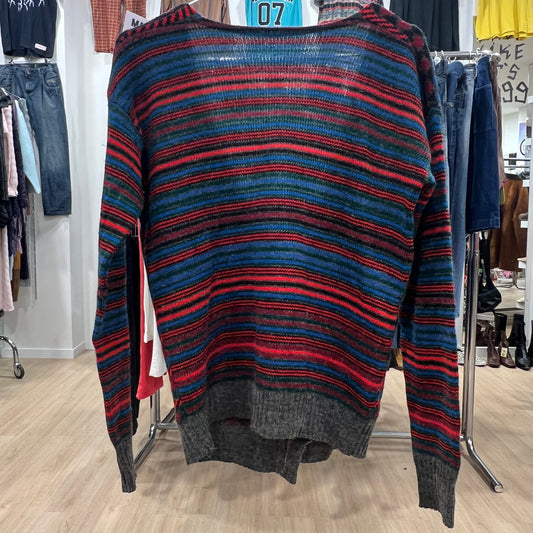 Striped sweater with red and blue pattern on a rack in a store setting