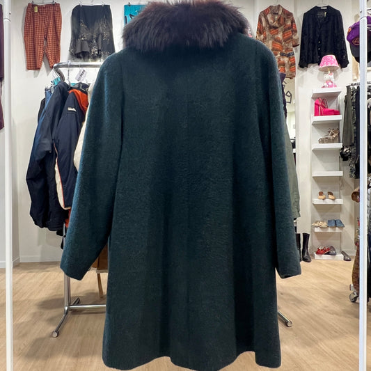 Dark green coat with fur collar in a clothing store