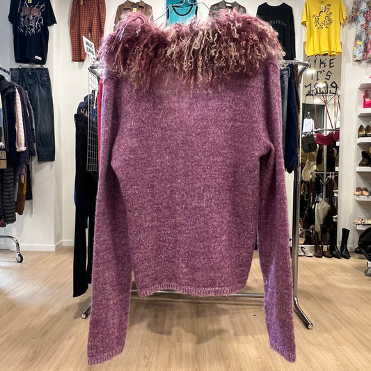 Purple sweater with fur trim on a rack in a clothing store