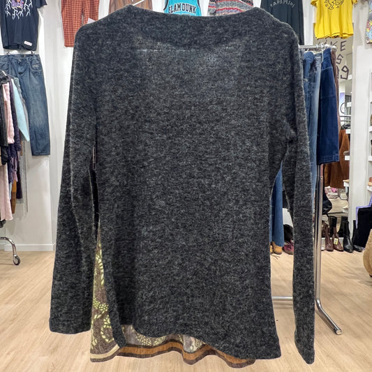 Dark gray cardigan with lace trim on a hanger in a clothing store