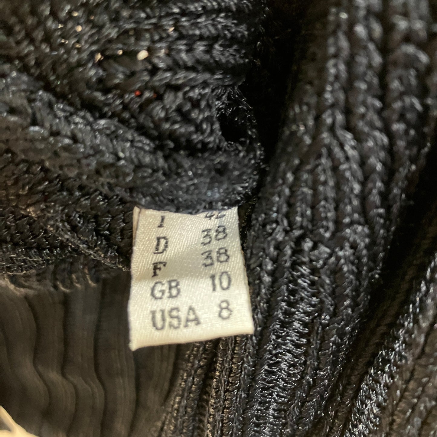 Close-up of a size label on a textured black fabric background