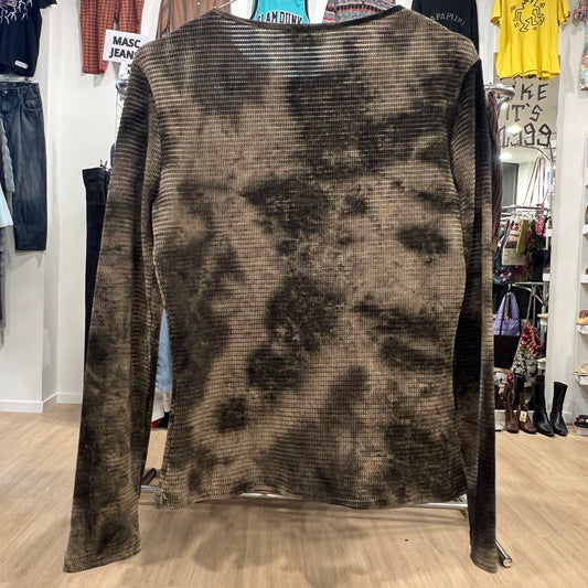 Back view of a long-sleeve ribbed top with a brown and black tie-dye effect, displayed on a hanger inside a vintage clothing store