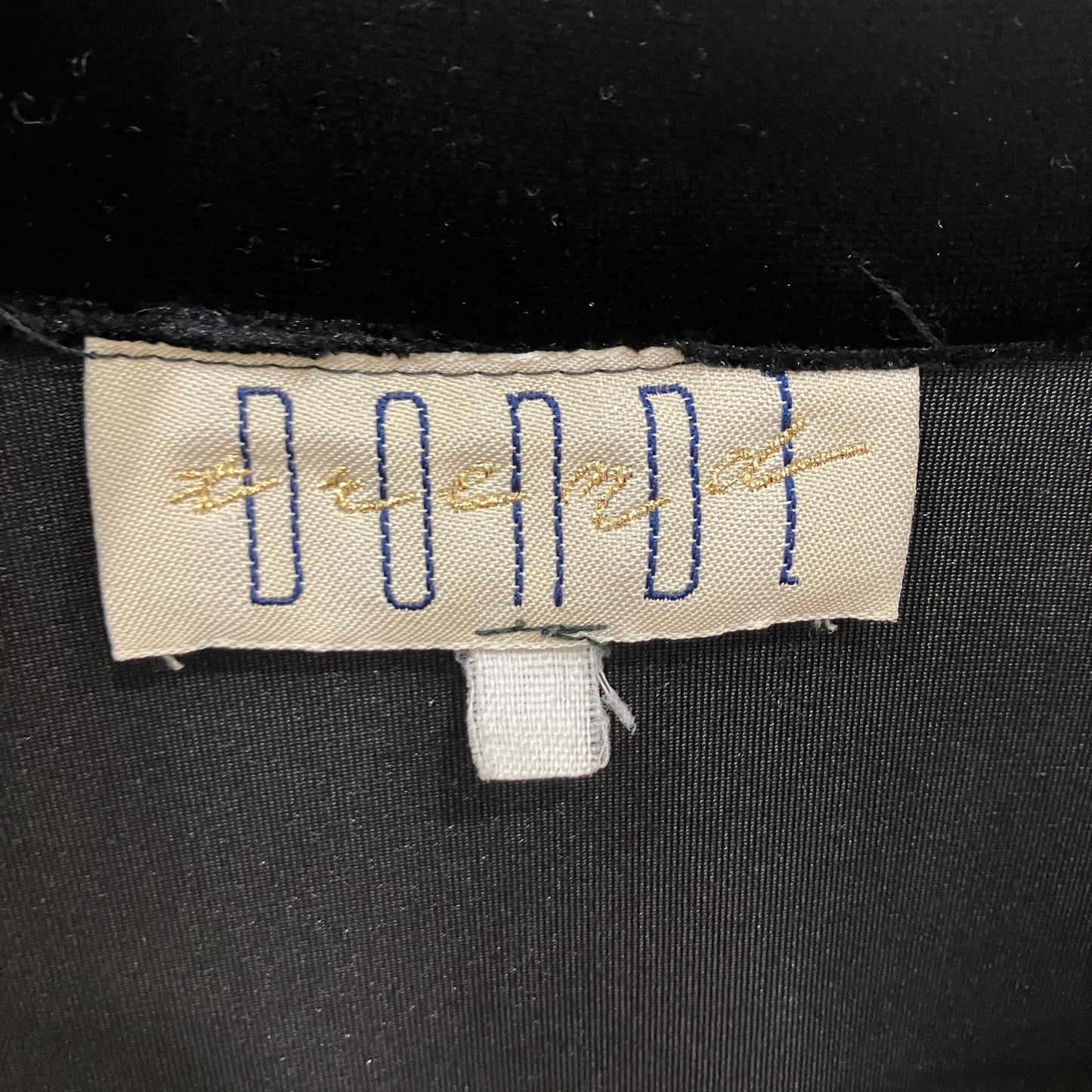 Label on a black garment with visible text