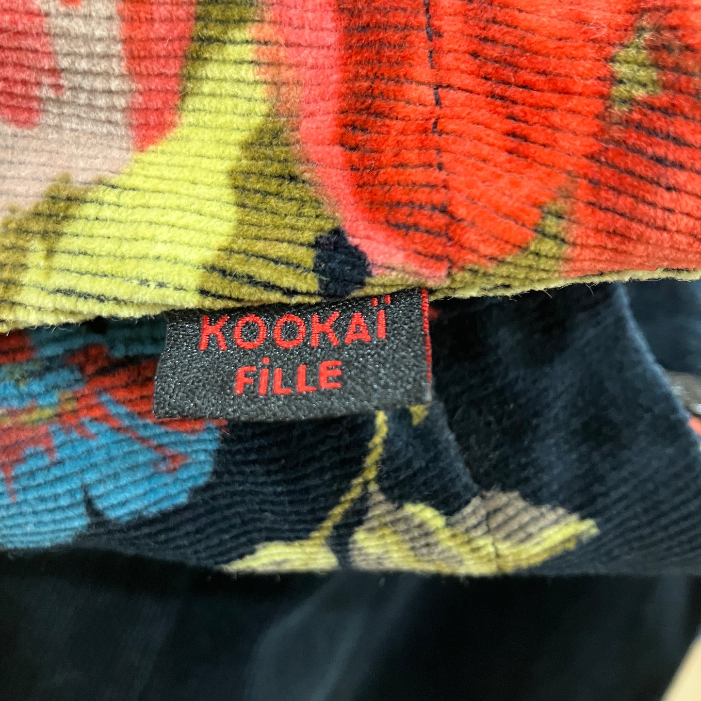 Close-up of a colorful fabric with a Kookai Fille label