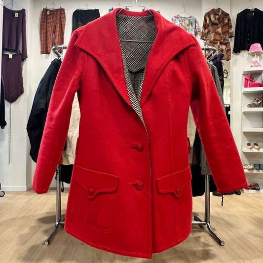 Red coat displayed in a store with various clothing items in the background