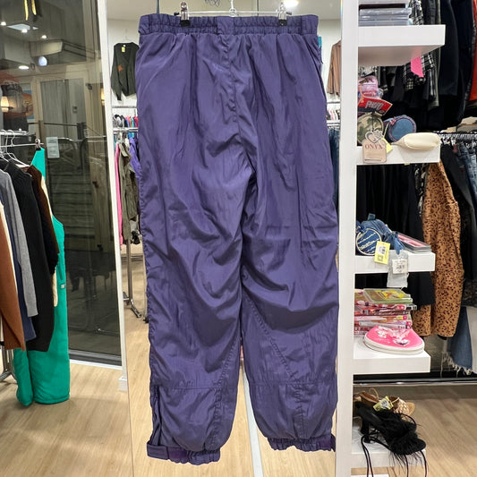 Purple pants hanging in a store with clothing racks and shelves in the background