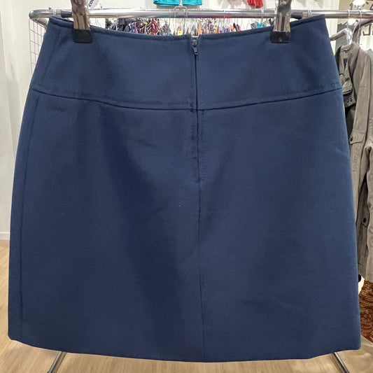 Navy blue skirt on a hanger against a clothing store background