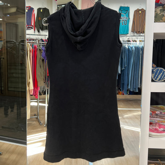 Black sleeveless dress with a hood on a hanger in a store setting