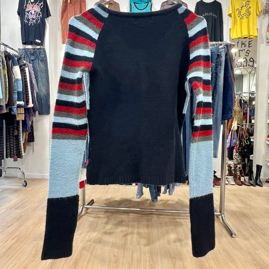 Blue sweater with colorful sleeves on a rack in a clothing store