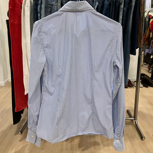Blue and white striped shirt on a hanger in a clothing store