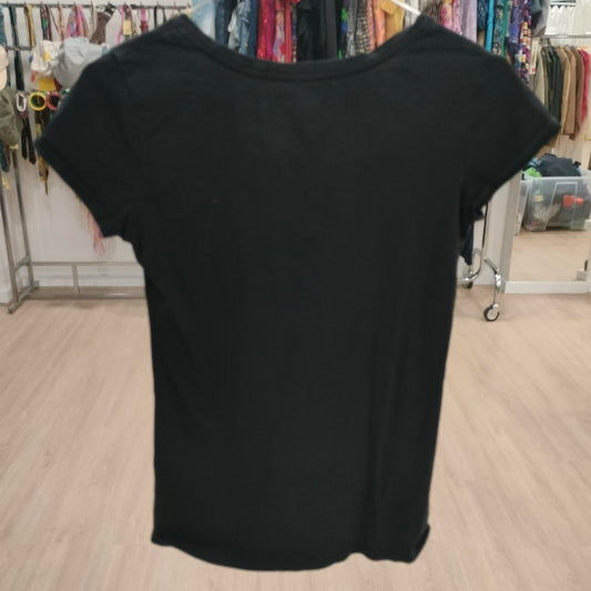 Black t-shirt on a hanger in a store setting